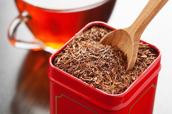 rooibos in tea tin box and wooden spoon closeup